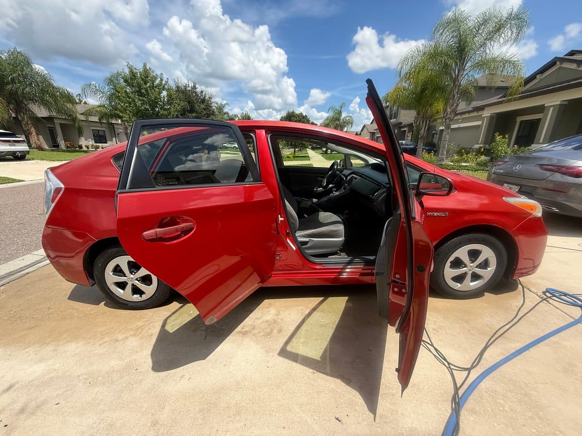 Freshly detailed red Toyota Prius with doors open