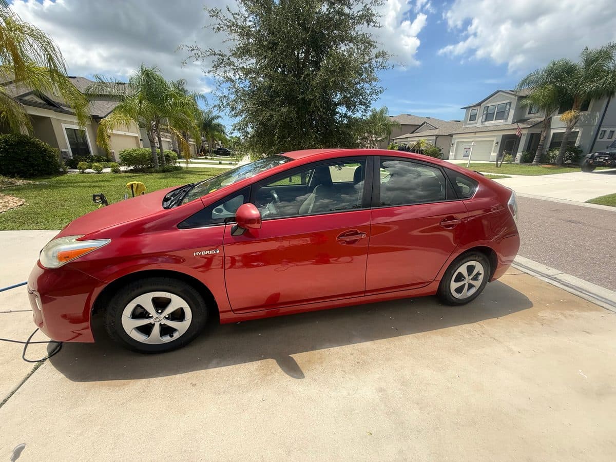 Detailed red Toyota Prius with a glossy side profile